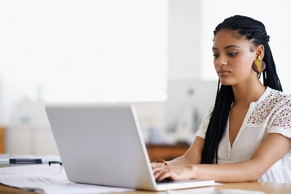 Young woman sitting at a table using a laptop