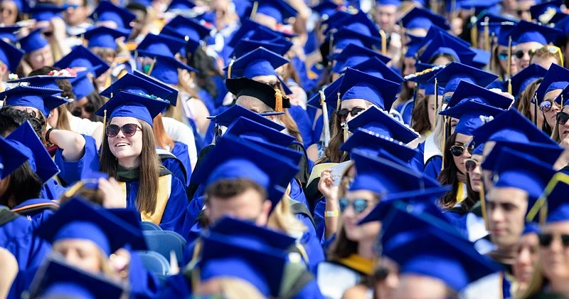 Students wearing blue graduation caps at Commencement